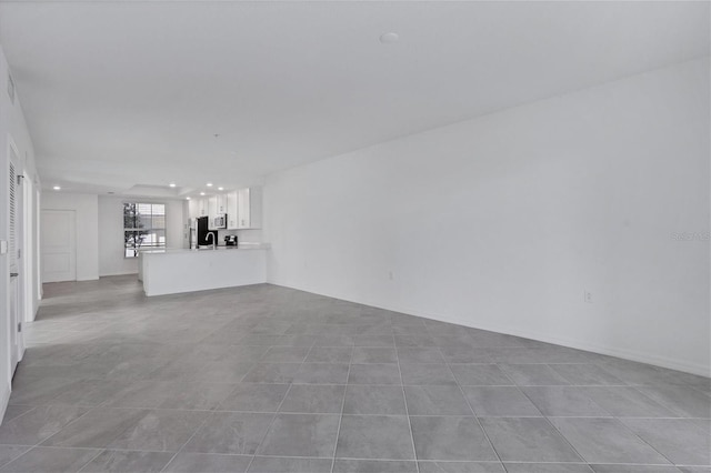 unfurnished living room featuring recessed lighting