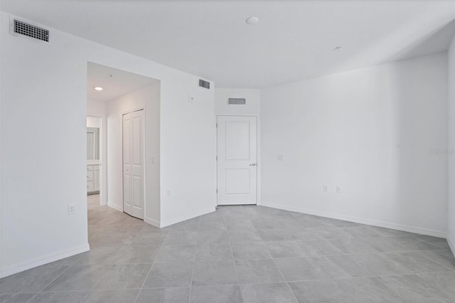 spare room with baseboards and visible vents