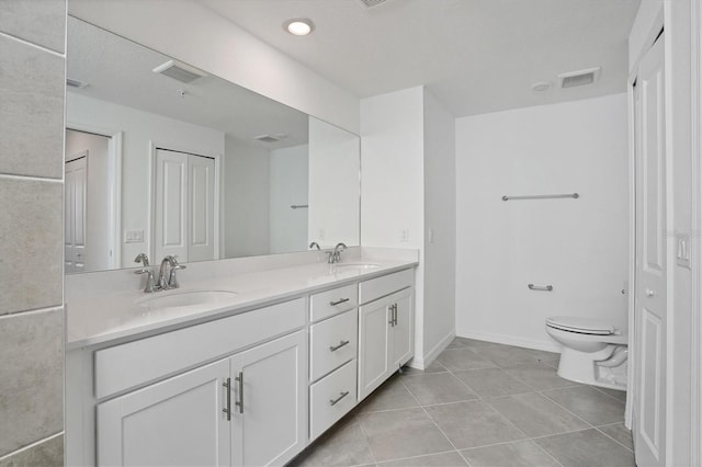 bathroom with double vanity, visible vents, toilet, tile patterned floors, and a sink