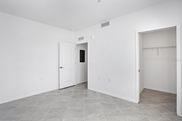 unfurnished bedroom with baseboards, a spacious closet, visible vents, and a closet