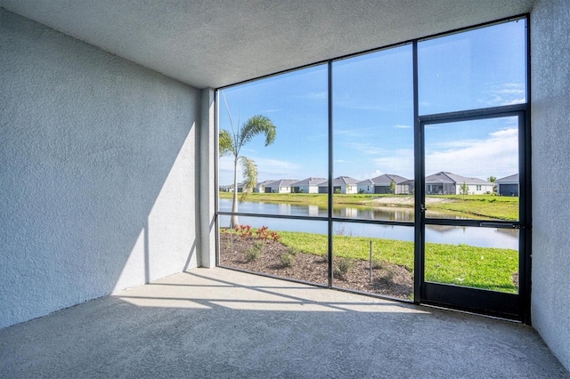 unfurnished sunroom featuring a residential view and a water view