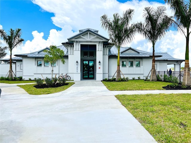 view of front of house with french doors, metal roof, a front lawn, and a standing seam roof