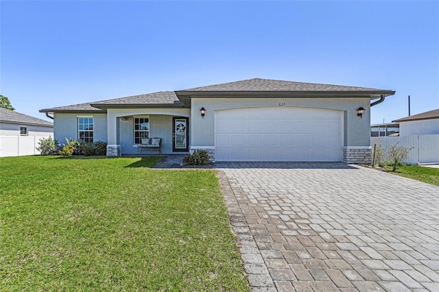 ranch-style house with a garage, decorative driveway, fence, and stucco siding