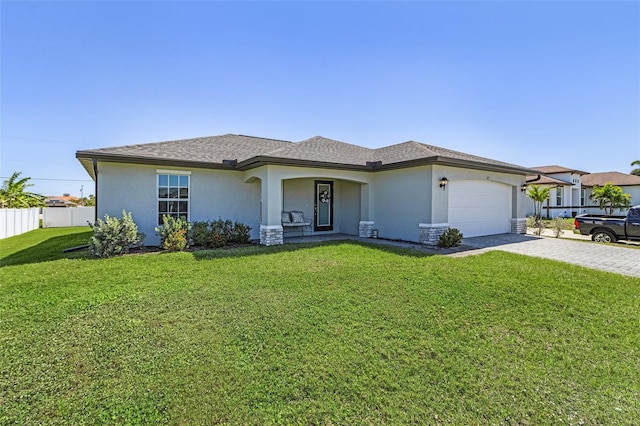 view of front of home with a garage, stucco siding, decorative driveway, and a front yard