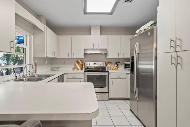 kitchen with under cabinet range hood, light countertops, light tile patterned floors, appliances with stainless steel finishes, and a sink