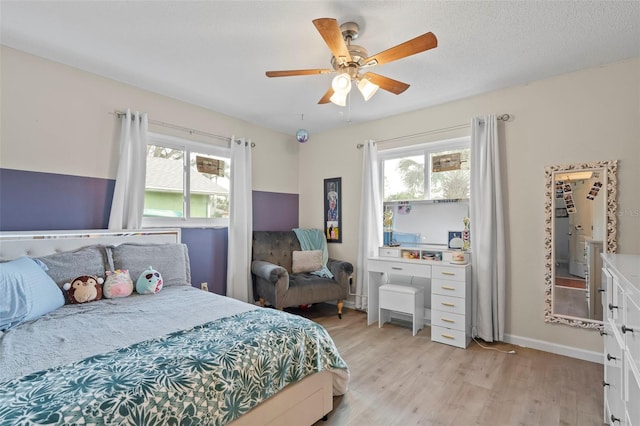 bedroom featuring multiple windows, baseboards, light wood-type flooring, and ceiling fan