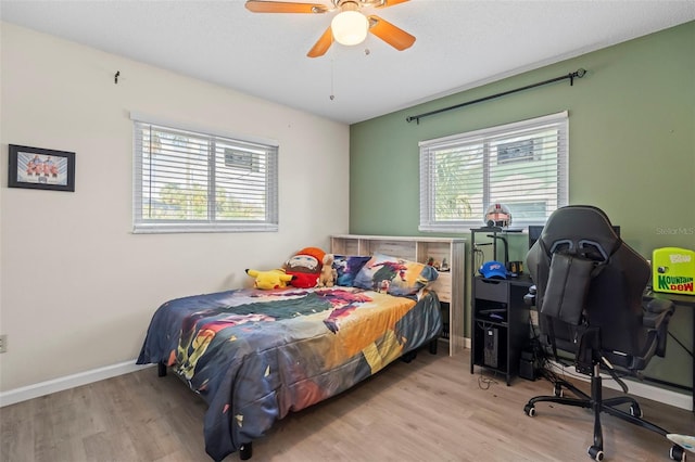 bedroom featuring ceiling fan, baseboards, and wood finished floors