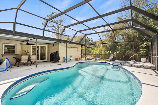 view of pool featuring a lanai, a pool with connected hot tub, ceiling fan, and a patio area