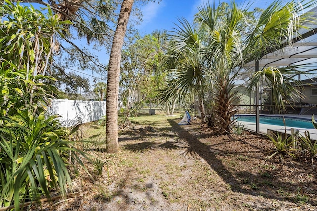 view of yard with glass enclosure, a fenced in pool, and fence