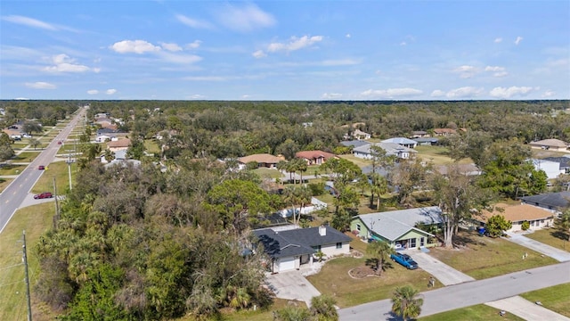 drone / aerial view featuring a residential view and a view of trees