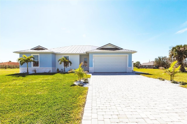 single story home with a garage, metal roof, a standing seam roof, decorative driveway, and a front lawn