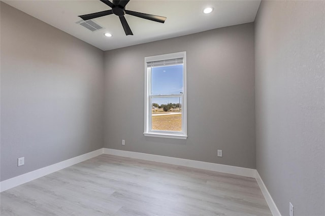 empty room with light wood-style floors, baseboards, visible vents, and a ceiling fan