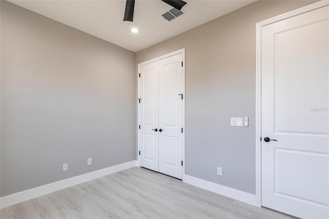 unfurnished bedroom with baseboards, visible vents, a ceiling fan, light wood-style flooring, and a closet