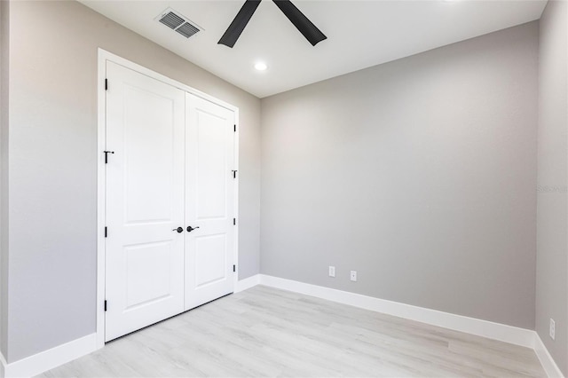 unfurnished bedroom with light wood finished floors, a closet, visible vents, and baseboards