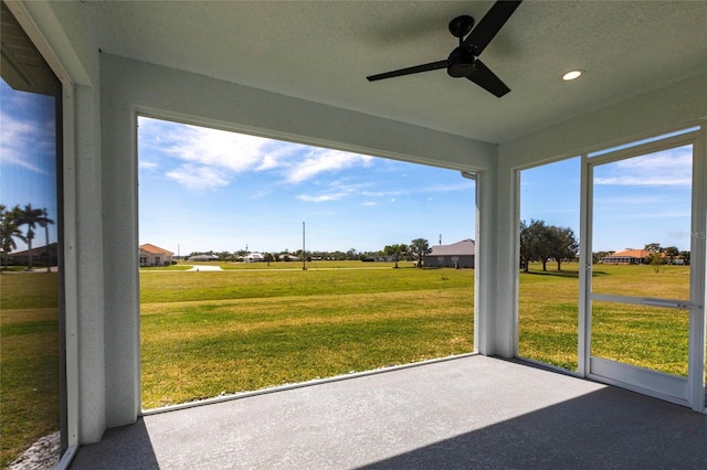 unfurnished sunroom featuring a ceiling fan