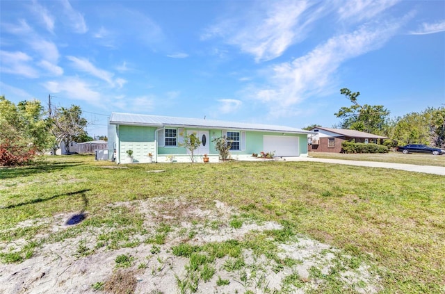 single story home featuring concrete driveway, an attached garage, a front yard, and metal roof