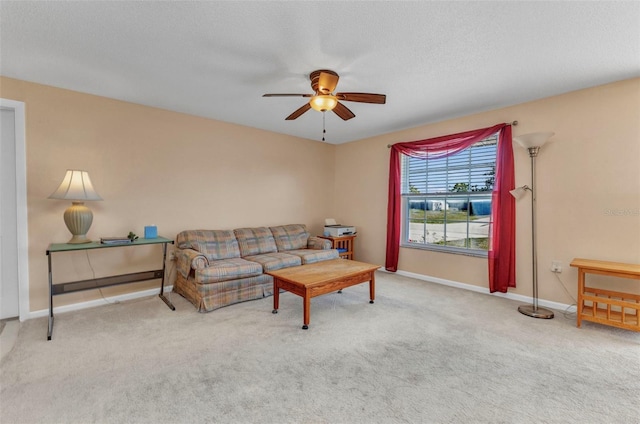 carpeted living room with a textured ceiling, baseboards, and a ceiling fan