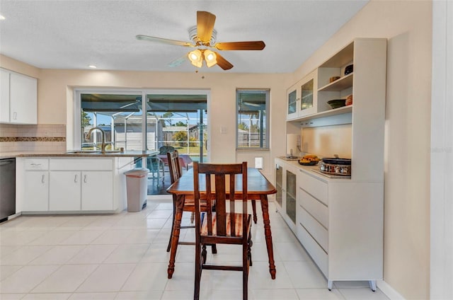 dining room featuring light tile patterned floors, baseboards, a textured ceiling, and ceiling fan