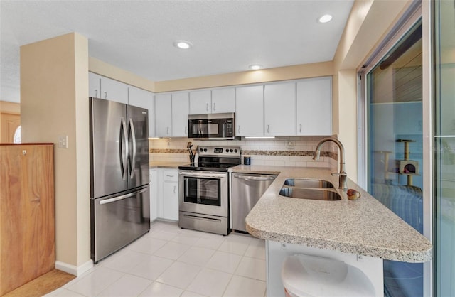 kitchen with a sink, light countertops, tasteful backsplash, and stainless steel appliances