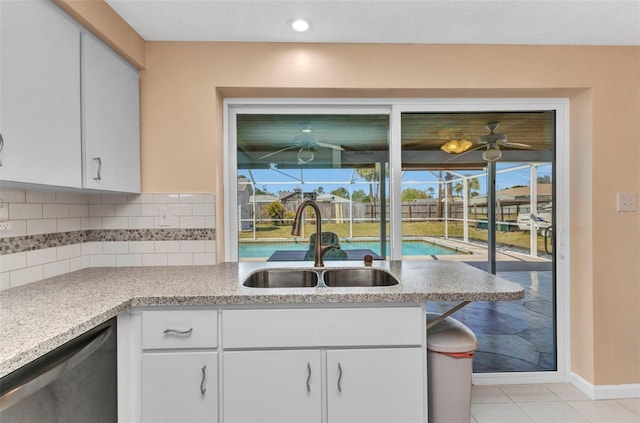 kitchen with a sink, tasteful backsplash, white cabinets, a sunroom, and dishwasher