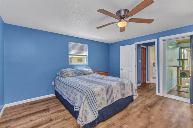 bedroom with baseboards, a textured ceiling, and wood finished floors