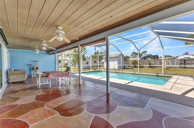 view of pool featuring glass enclosure, a patio, fence, a fenced in pool, and a ceiling fan