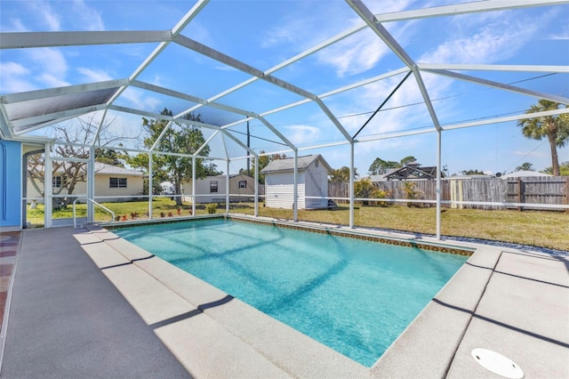 view of pool featuring a shed, a fenced backyard, an outdoor structure, a patio area, and a lawn