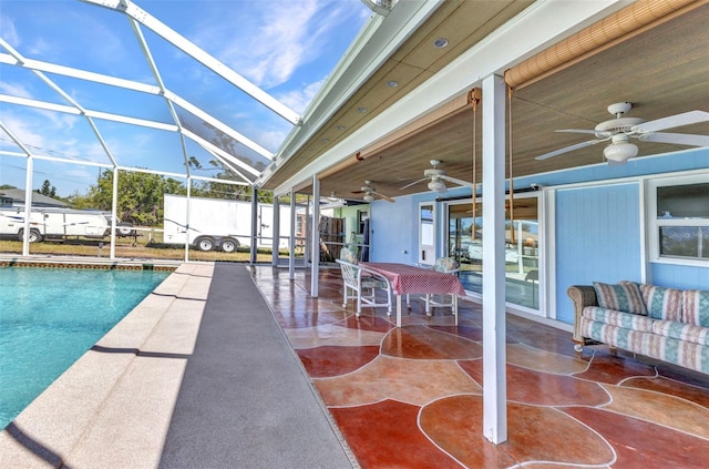 view of swimming pool with a patio area, glass enclosure, and ceiling fan