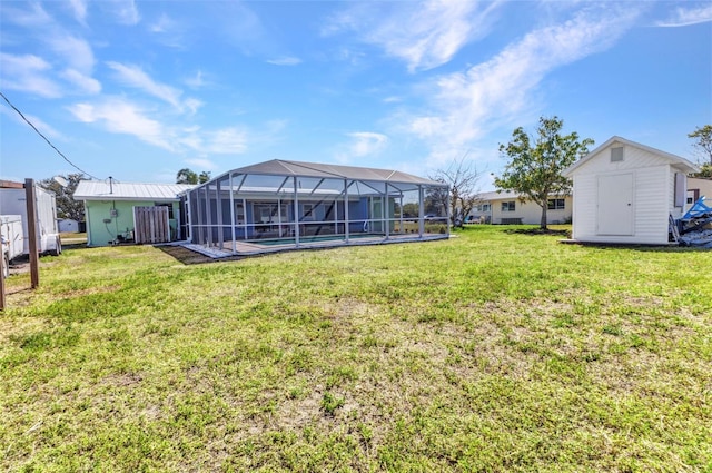 view of yard with an outbuilding, a swimming pool, a storage unit, and a lanai