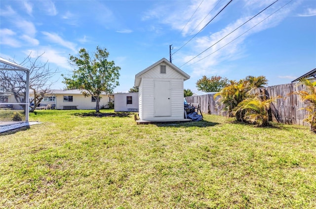 view of yard with an outdoor structure, a storage unit, and fence private yard