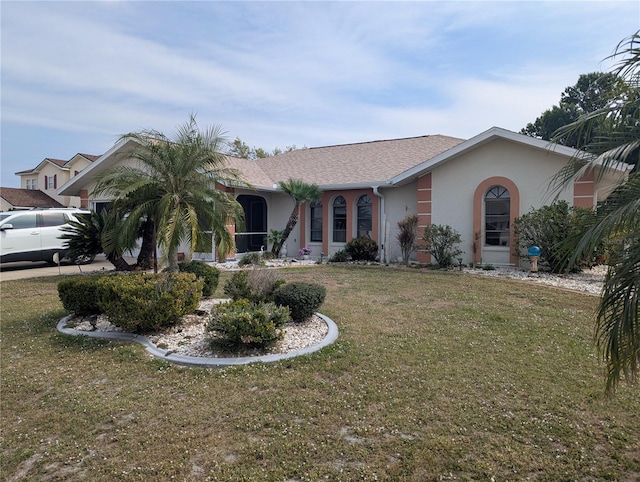 single story home featuring stucco siding and a front yard