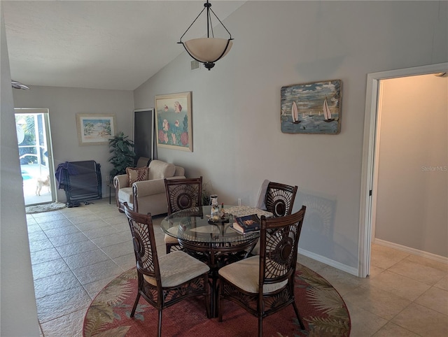 dining room featuring light tile patterned floors, baseboards, lofted ceiling, and visible vents