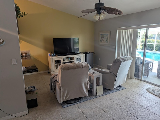 living area featuring tile patterned floors, baseboards, and ceiling fan