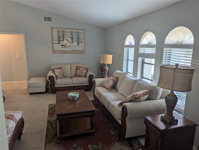 living room featuring tile patterned flooring, visible vents, and lofted ceiling