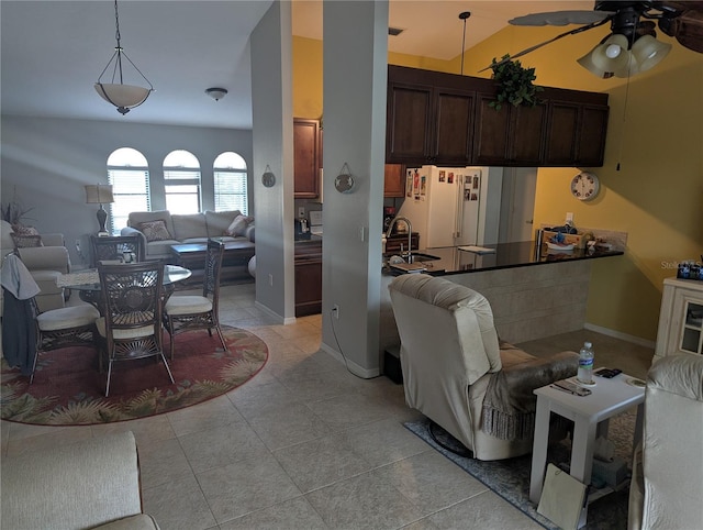 kitchen with dark brown cabinetry, open floor plan, freestanding refrigerator, and a ceiling fan