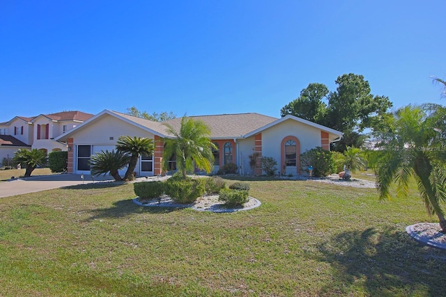 view of front of house with a front lawn, a garage, driveway, and stucco siding