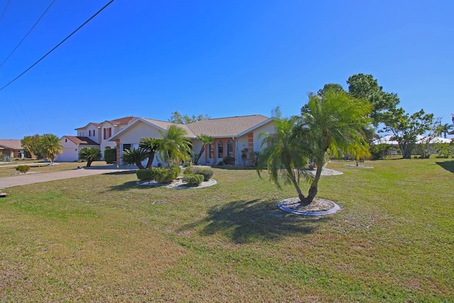 view of front of house with concrete driveway and a front lawn