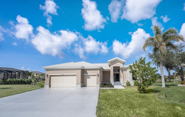 17261 Naiad Ct, Punta Gorda, FL 33955 - prairie-style house featuring an attached garage, a standing seam roof, a front yard, driveway, and stone siding