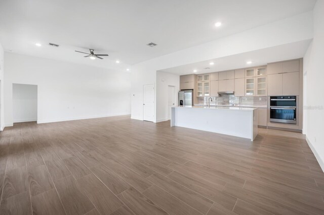 17261 Naiad Ct, Punta Gorda, FL 33955 - unfurnished living room with light wood-style flooring, a ceiling fan, recessed lighting, baseboards, and a sink
