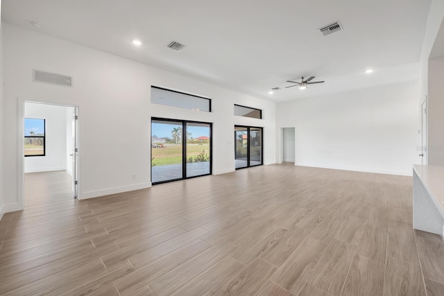 17261 Naiad Ct, Punta Gorda, FL 33955 - unfurnished living room featuring a ceiling fan, light wood-style floors, recessed lighting, baseboards, and a high ceiling