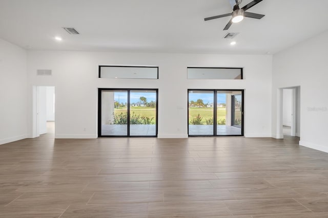 17261 Naiad Ct, Punta Gorda, FL 33955 - unfurnished living room with recessed lighting, baseboards, a ceiling fan, a high ceiling, and light wood finished floors