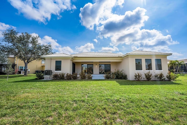 17261 Naiad Ct, Punta Gorda, FL 33955 - back of house featuring a standing seam roof, stucco siding, metal roof, and a lawn
