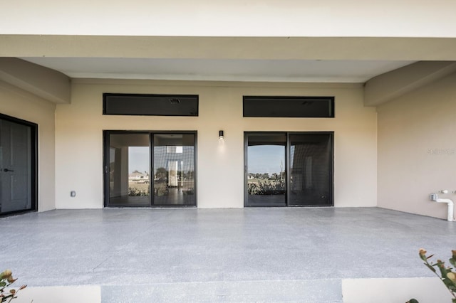 17261 Naiad Ct, Punta Gorda, FL 33955 - view of exterior entry featuring stucco siding and a patio