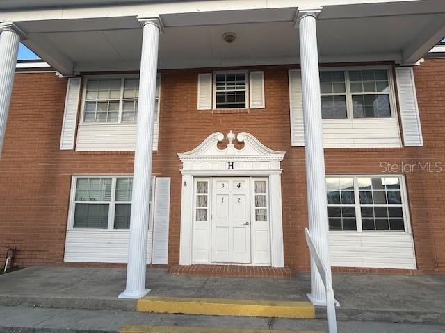 entrance to property featuring brick siding