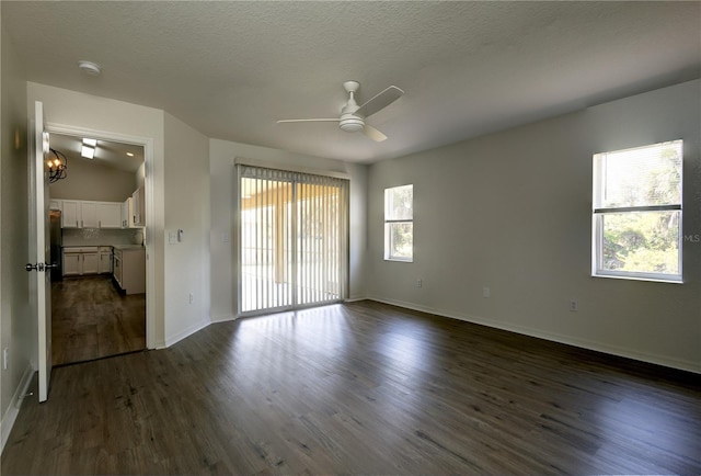 unfurnished room featuring baseboards, a textured ceiling, ceiling fan, and dark wood-style flooring