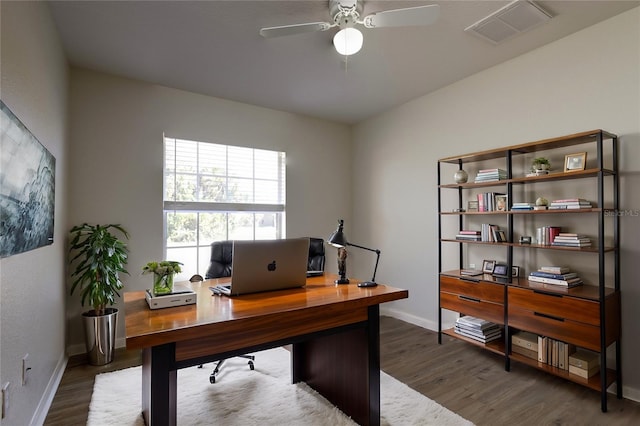 home office featuring visible vents, ceiling fan, dark wood-type flooring, and baseboards