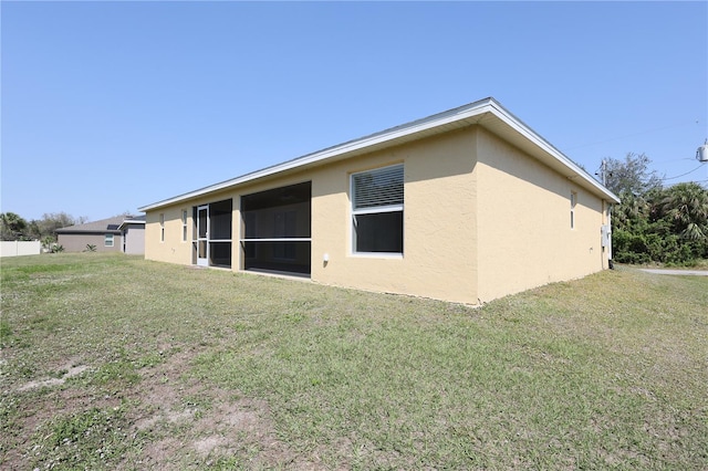 exterior space with stucco siding and a yard