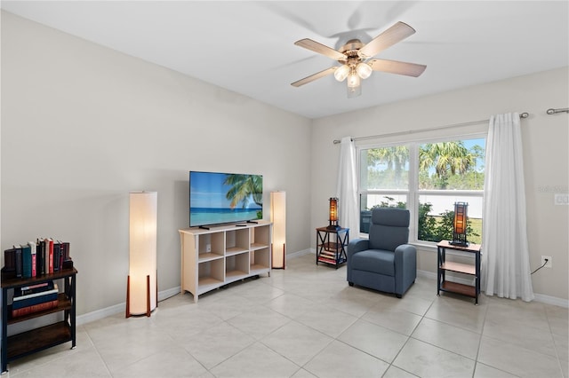 sitting room featuring light tile patterned floors, baseboards, and a ceiling fan