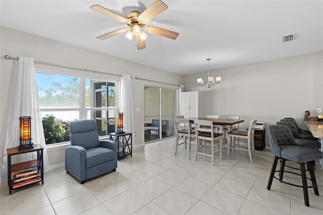 dining room featuring light tile patterned floors, visible vents, ceiling fan with notable chandelier, and baseboards