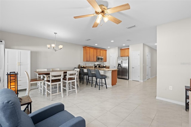 living room with visible vents, recessed lighting, ceiling fan with notable chandelier, and baseboards